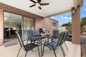 a patio with a table and chairs and a ceiling fan at 28 Skye Ave - Skye High on Style in Moama