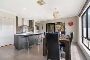 a kitchen with a table and chairs and a dining room at 28 Skye Ave - Skye High on Style in Moama