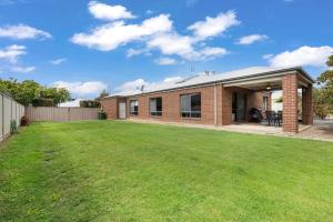 a brick house with a lawn in front of it at 28 Skye Ave - Skye High on Style in Moama