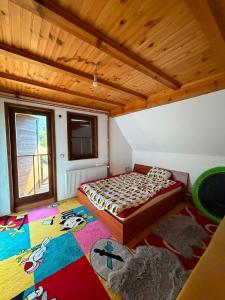 a bedroom with a bed and a large rug at Winter Dream Vlašić in Šišava