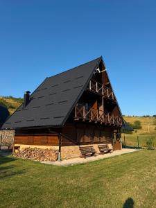 a large log cabin with a black roof at Winter Dream Vlašić in Šišava