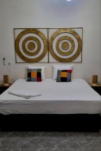 a bedroom with a large bed with pillows on it at Kër Mouna MJN Hotels in Diass