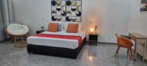 a bedroom with a bed and a table and a chair at Kër Mouna MJN Hotels in Diass