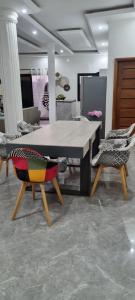 a dining room with a table and two chairs at Kër Mouna MJN Hotels in Diass