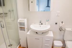 a white bathroom with a sink and a shower at Apartamento Aira 2 in Villadepalos