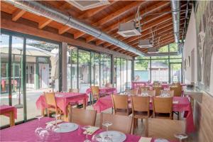 a restaurant with pink tables and chairs and windows at Apartamento Aira 2 in Villadepalos