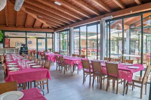 a restaurant with pink tables and chairs and windows at Apartamento Aira 2 in Villadepalos +59 photos