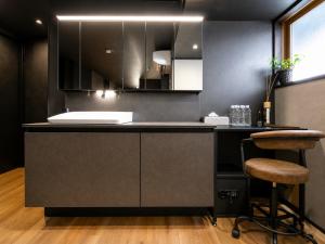 a kitchen with a black counter and a stool at Jaune Chalet in Hakuba +47 photos