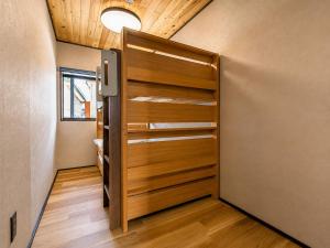 a closet with a wooden door in a room at Jaune Chalet in Hakuba