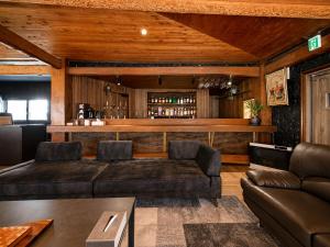 a living room with a couch and a bar at Jaune Chalet in Hakuba