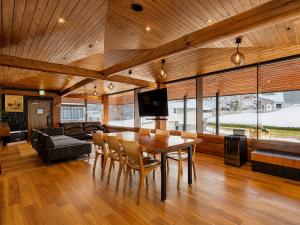 a dining room with a table and chairs and a couch at Jaune Chalet in Hakuba