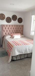 a bedroom with a large bed with a pink headboard at My Bunker in Cali