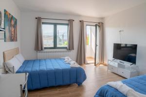 a bedroom with a blue bed and a television at Habitaciones Aira in Villadepalos