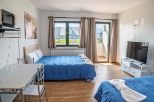 a bedroom with a bed and a tv and a couch at Habitaciones Aira in Villadepalos