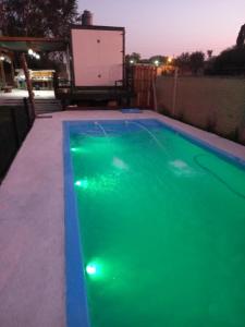 a swimming pool with green water at night at Quinta los acuelos in Luján