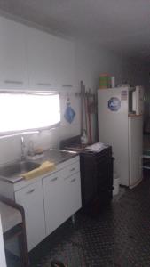 a small kitchen with a sink and a refrigerator at Quinta los acuelos in Luján