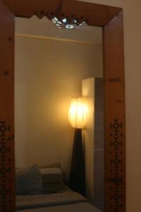 a bedroom with a bed and a lamp in a mirror at Hobbiton in Agadir