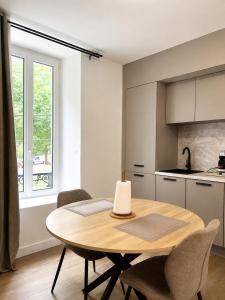 a kitchen and dining room with a wooden table and chairs at LOCAPONDI 5 - Les Reflets du Canal in Pontivy