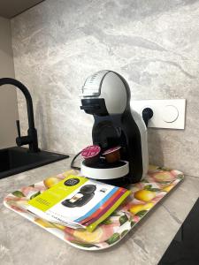 a coffee maker sitting on a plate on a counter at LOCAPONDI 5 - Les Reflets du Canal in Pontivy +7 photos