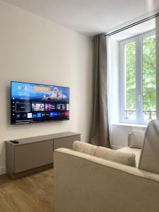 a living room with a flat screen tv on the wall at LOCAPONDI 5 - Les Reflets du Canal in Pontivy
