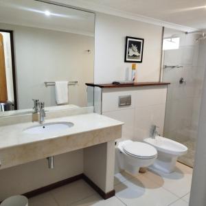 a bathroom with a sink and a toilet and a mirror at Sunset Cottage in Langebaan +29 photos