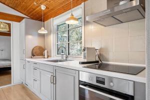 a kitchen with white cabinets and a sink and a window at 1087-Stege-Berberisvej-7 in Stege +14 photos