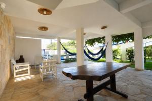 a living room with a wooden table and chairs at Pousada Villa Grécia in Aracaju