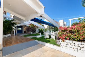 a patio of a building with chairs and flowers at Pousada Villa Grécia in Aracaju