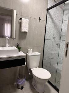 a bathroom with a toilet and a sink and a shower at Spazio Cristalli Comfort in Cuiabá