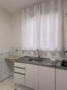 a kitchen with a sink and a window at Spazio Cristalli Comfort in Cuiabá