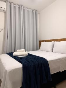 a bedroom with two beds with white sheets at Spazio Cristalli Comfort in Cuiabá