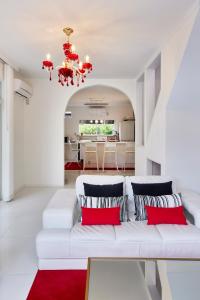 a living room with a white couch with red pillows at Sea Shell Kawazu House in Kawazu