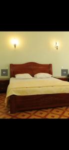 a bed with a wooden headboard in a bedroom at DAVID Hotel in Yerevan