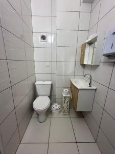 a white bathroom with a toilet and a sink at KITNETS Kretzer Hinckel 2 - CENTRO in Alfredo Wagner