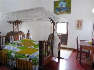 a bedroom with a bed with a canopy at The Old Boma Hotel in Mtwara