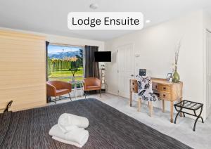 a room with a bed and a desk and chairs at Vibrant Living Retreat in Hanmer Springs