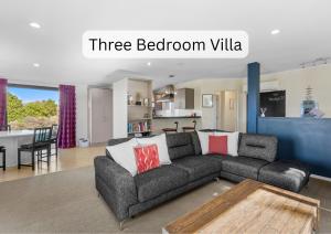 a living room with a couch and a kitchen at Vibrant Living Retreat in Hanmer Springs
