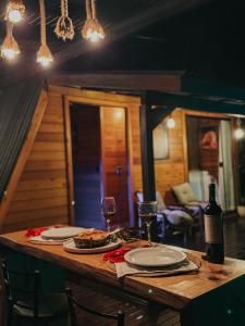 a table with plates of food and a bottle of wine at cabana ret in Alfredo Wagner