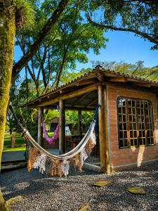 a hammock in front of a small building at Chalé Pé da Serra in Treviso