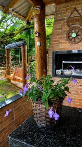 a basket of flowers on a table with a brick fireplace at Chalé Pé da Serra in Treviso