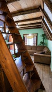 a wooden staircase in a living room with a couch at Chalé Pé da Serra in Treviso