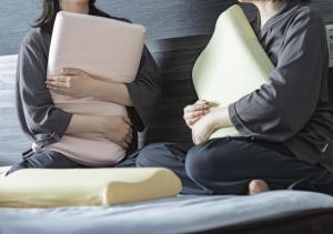 two women sitting on a bed holding pillows at Super Hotel Hida Takayama in Takayama +80 photos