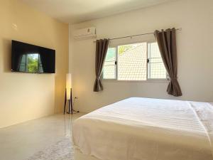 a bedroom with a large bed and a window at Duplex Villa 1 in Trat