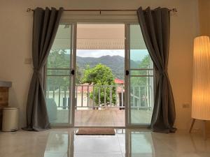 an open glass door with a view of a patio at Duplex Villa 1 in Trat