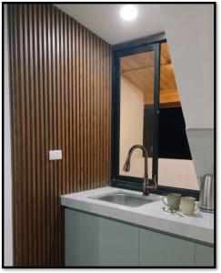 a kitchen with a sink and a mirror at Cabañas Cavanilla in Oxapampa