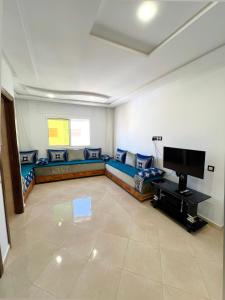 a living room with a couch and a flat screen tv at Visit Chamal - Palmera 4 in Oued Laou