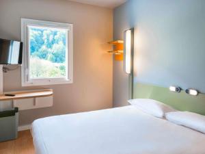 a bedroom with a white bed and a window at Ibis Budget Sallanches in Sallanches