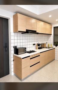 a kitchen with wooden cabinets and a stove top oven at Collins unique apartments in Ruaka