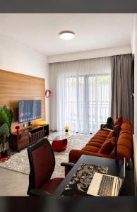 a living room with a couch and a flat screen tv at Collins unique apartments in Ruaka