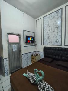 a bedroom with a bed with a swan on it at PONDOK CHILLY in Cirebon